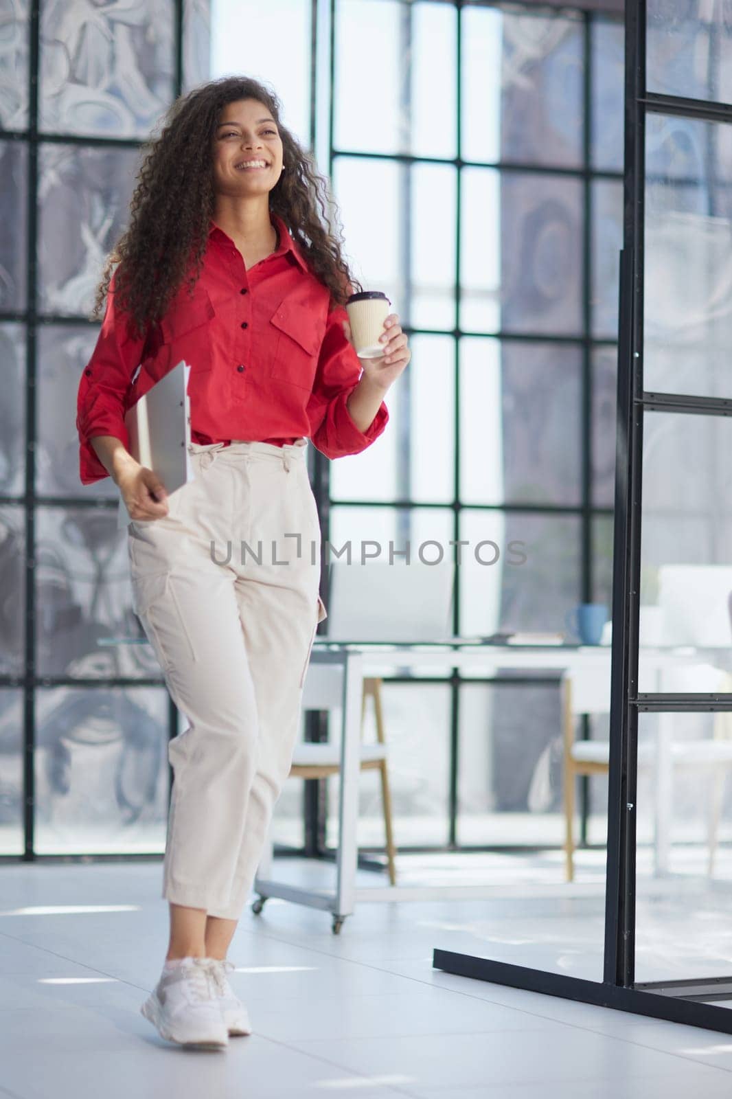 Im ready to start the day. an attractive young businesswoman standing alone in the office with her arms folded