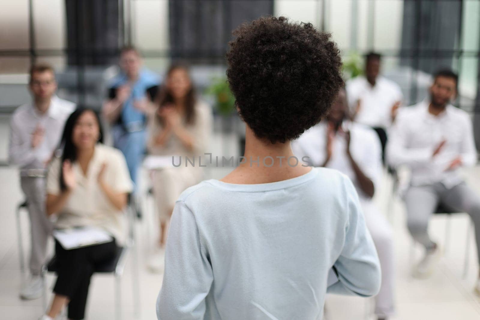 Selective focus of young businesswoman together with interracial colleagues during seminar