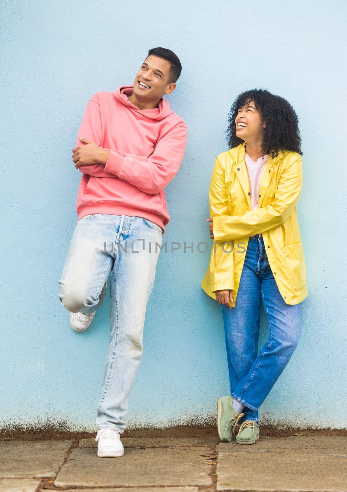Black couple, smile and casual fashion standing in urban town wall background for conversation, peace and relax together. Cool man, trendy woman and happy speaking for gen z millennial street style.