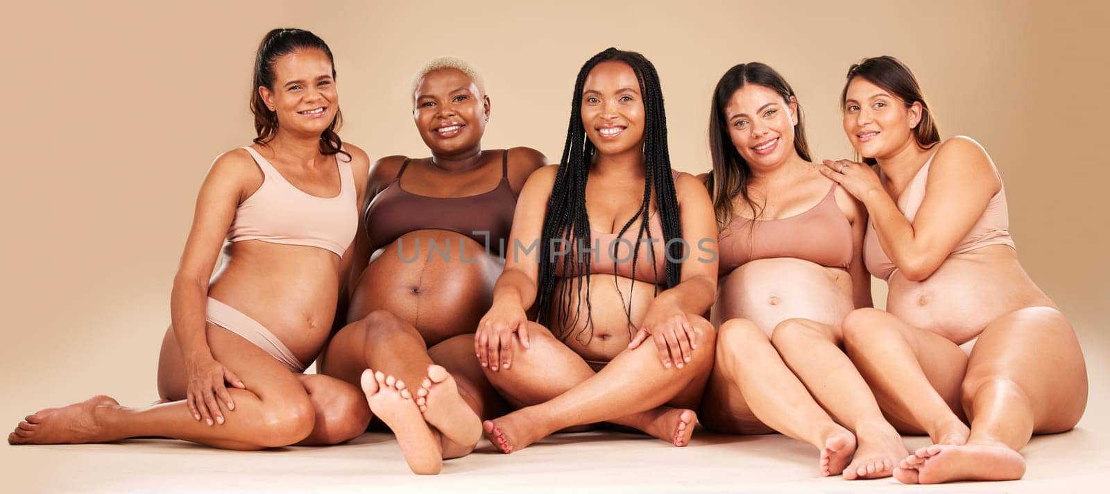 Portrait, group or pregnancy friends sitting in underwear in community bonding, diversity support or body empowerment. Happy smile, floor or pregnant women in healthcare wellness, future baby or love.