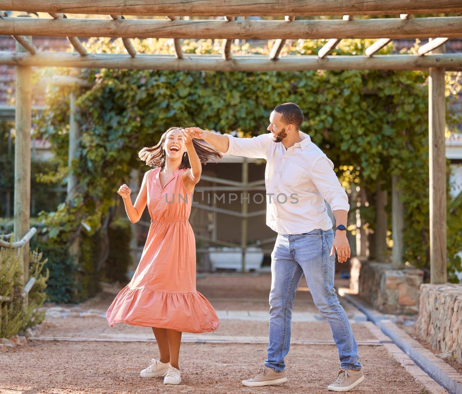 Couple, happy dancing together and outdoor love to celebrate relationship, cute dance spin and relationship activity. Woman laughing, romantic man and sunset summer romance date at nature restaurant.