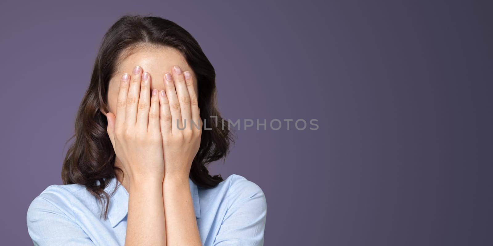 Woman portrait hides her face in her hands