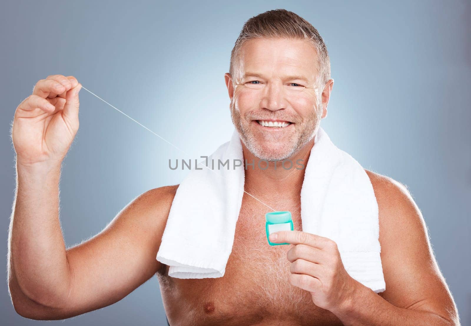 Dental, floss and portrait of man with product in studio isolated on a gray background. Oral hygiene, health and mature male model with container with thread for flossing, cleaning and teeth care. by YuriArcurs