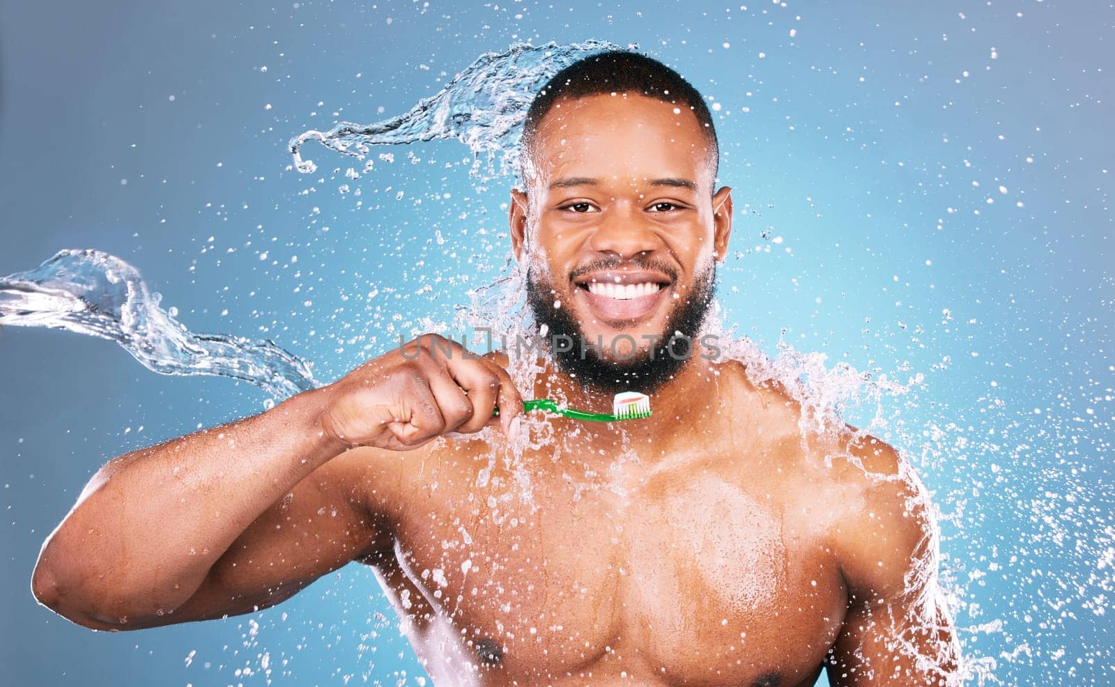 Black man, face and toothbrush with water and dental, brushing teeth and hygiene on blue background. Cleaning, wet splash and grooming, male in portrait and smile for oral care product and toothpaste.