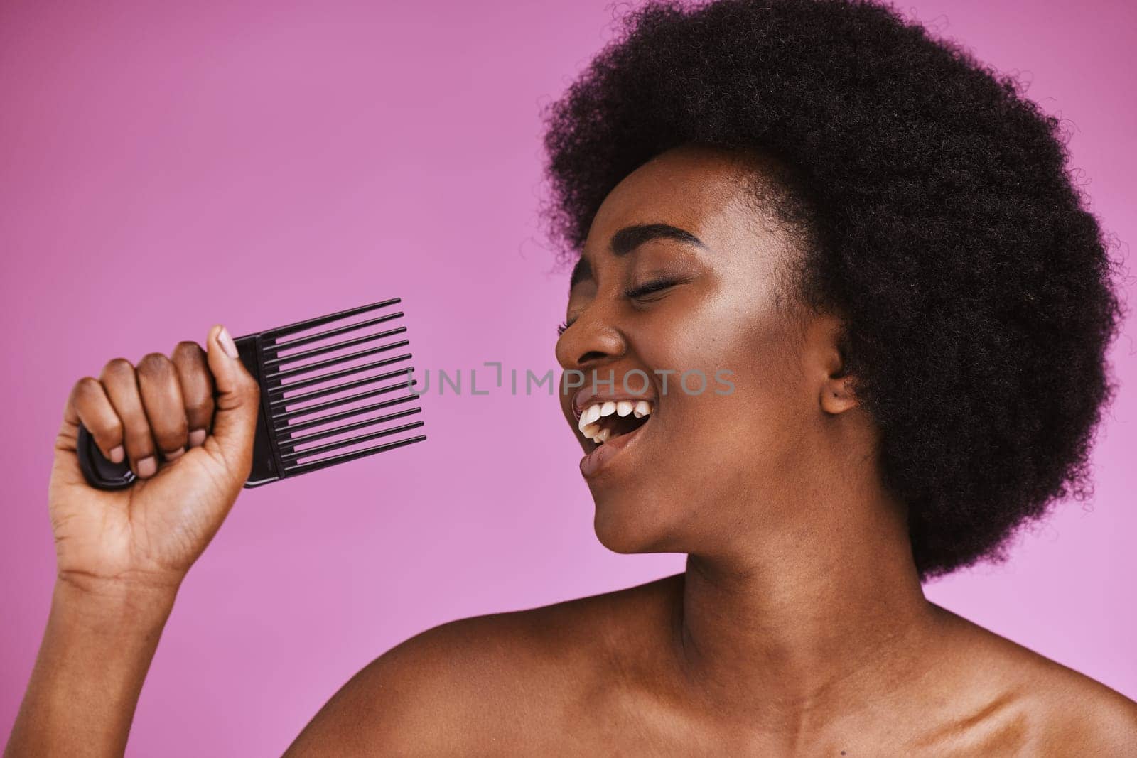 Singing, hair or afro comb on beauty background in fun grooming routine, natural skincare play or growth texture karaoke. Black woman, happy or hairstyle brush microphone on isolated pink performance.