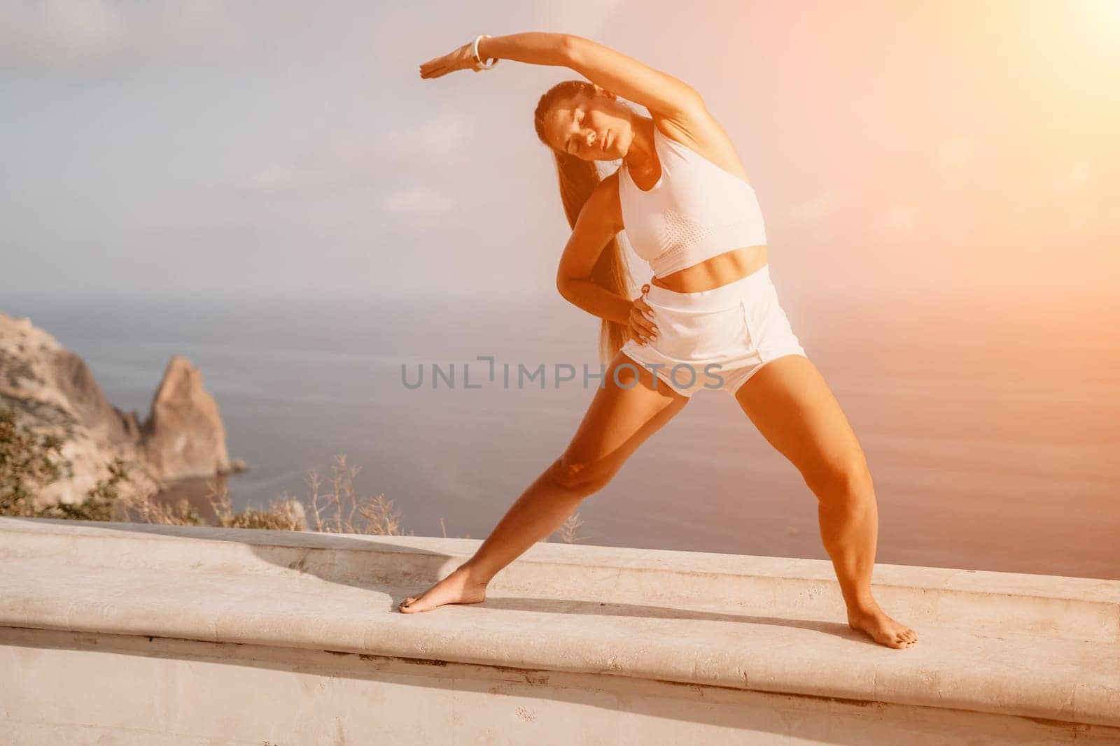 Fitness woman sea. Outdoor workout on yoga mat in park near to ocean beach. Female fitness pilates yoga routine concept. Healthy lifestyle. Happy fit woman exercising with rubber band in park.