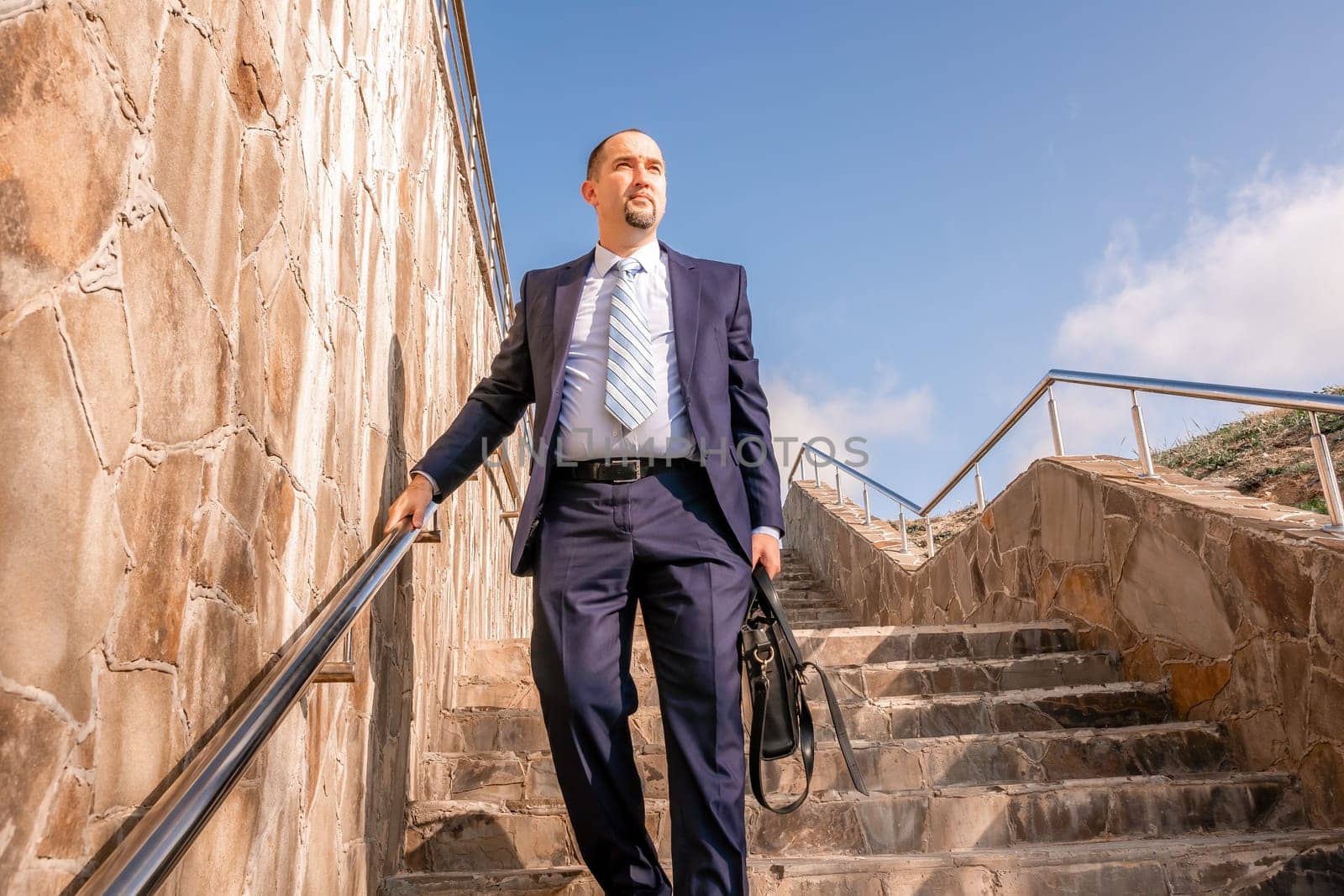 Business executive with briefcase going down the stairs.