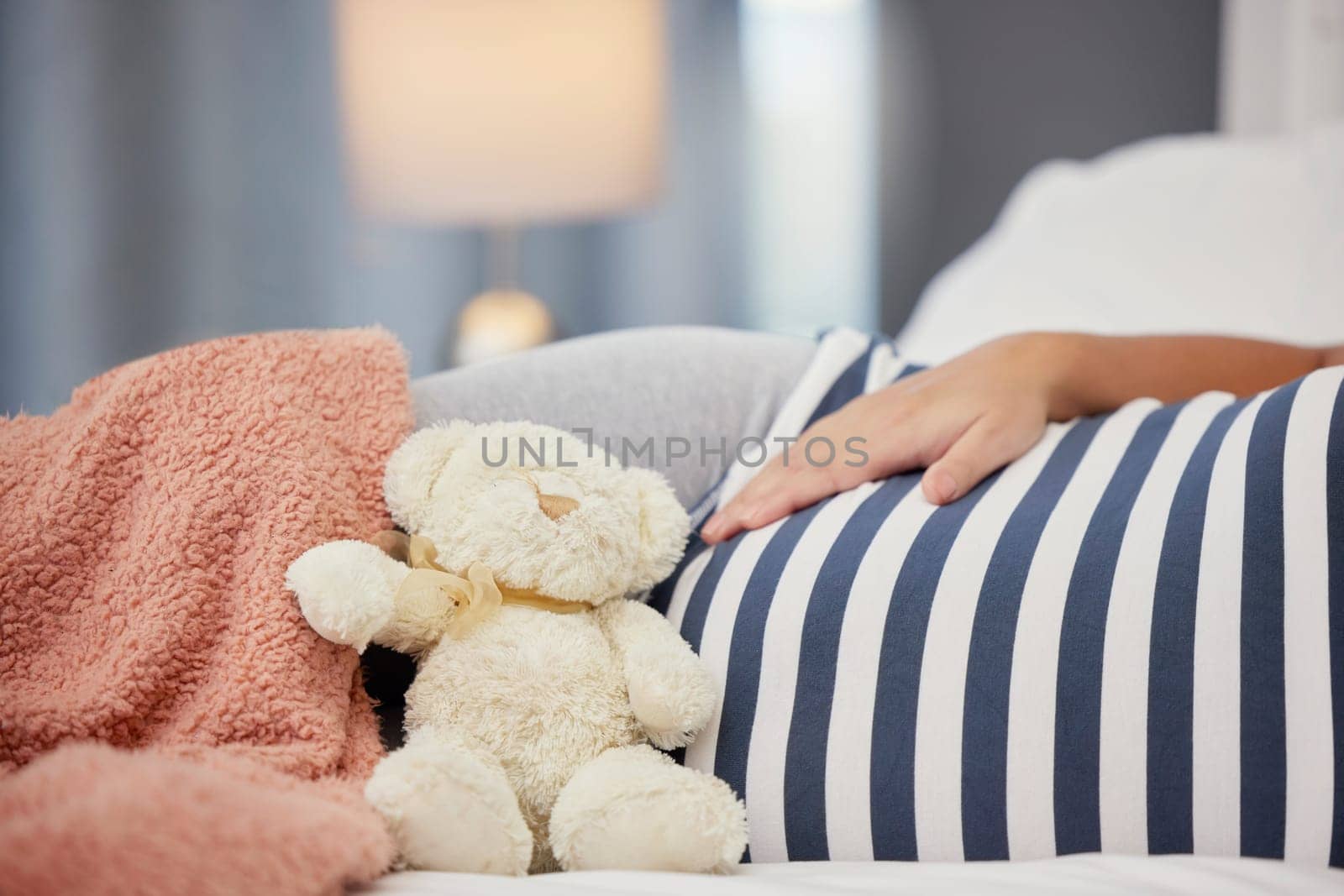 Pregnant stomach, teddy bear and mother in bed with toy for baby, infant and affection at home. Pregnancy love, family and excited, loving and happy woman rest, relaxing and calm in bedroom.