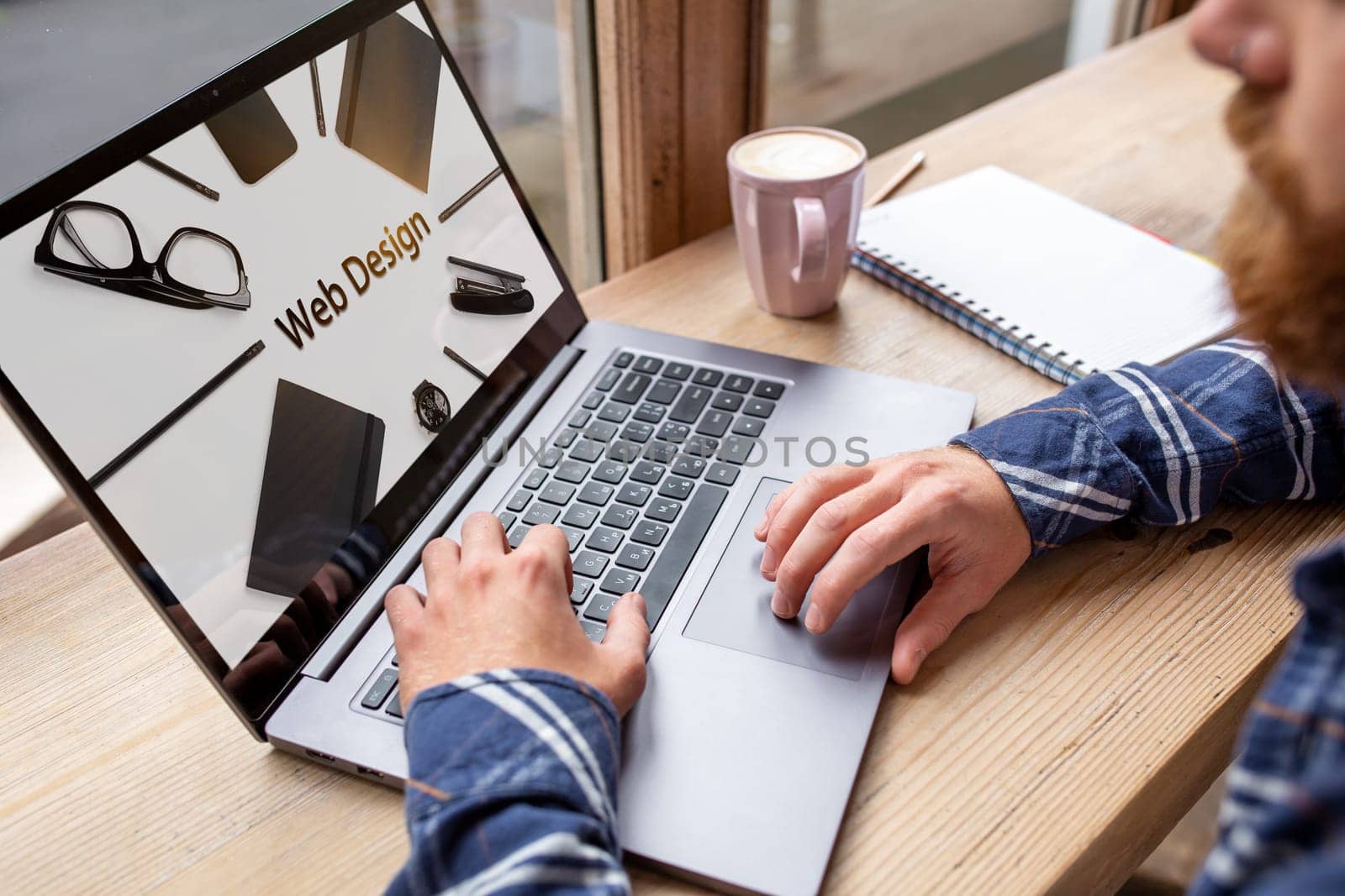 Cropped image of a young man working on his laptop in a coffee shop, rear view of business man hands busy using laptop at office desk, young male student texting on computer sitting at wooden table. Design. Web design