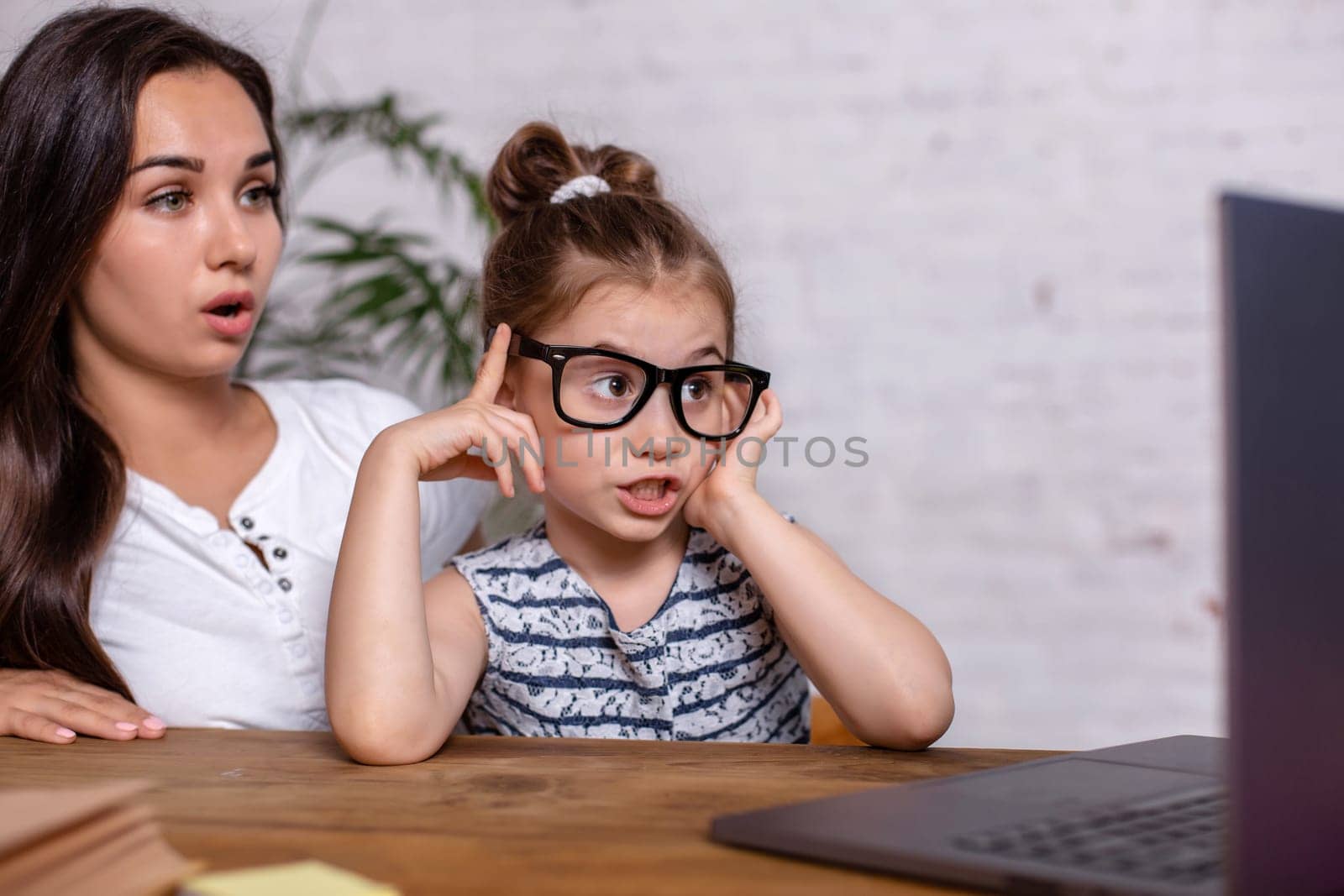 Irritated mother watching at the mistakes her daughter's homework by nazarovsergey