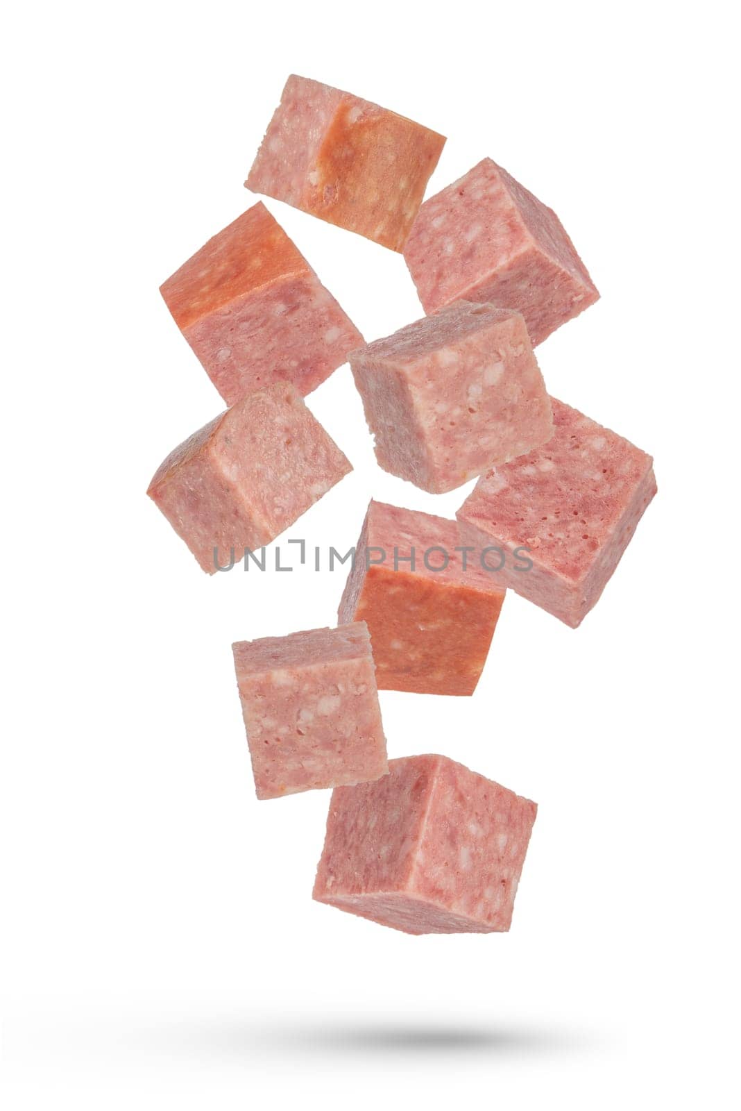 Flying sausage. Cubes of smoked sausage on a white isolated background. Salami cubes fall on a white background, for insertion into a design or project