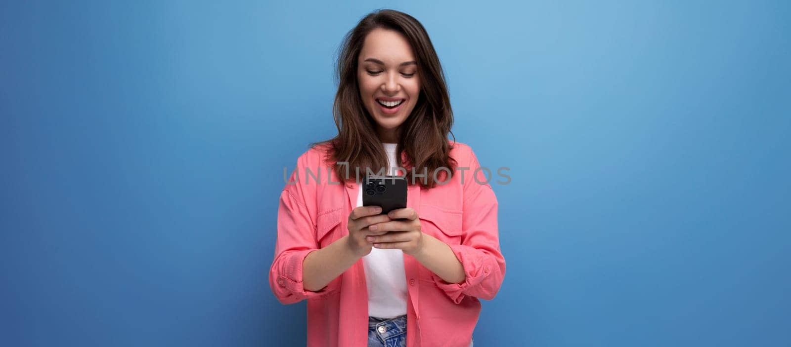 portrait of stylish dark haired young woman with hollywood smile isolated with studio background.