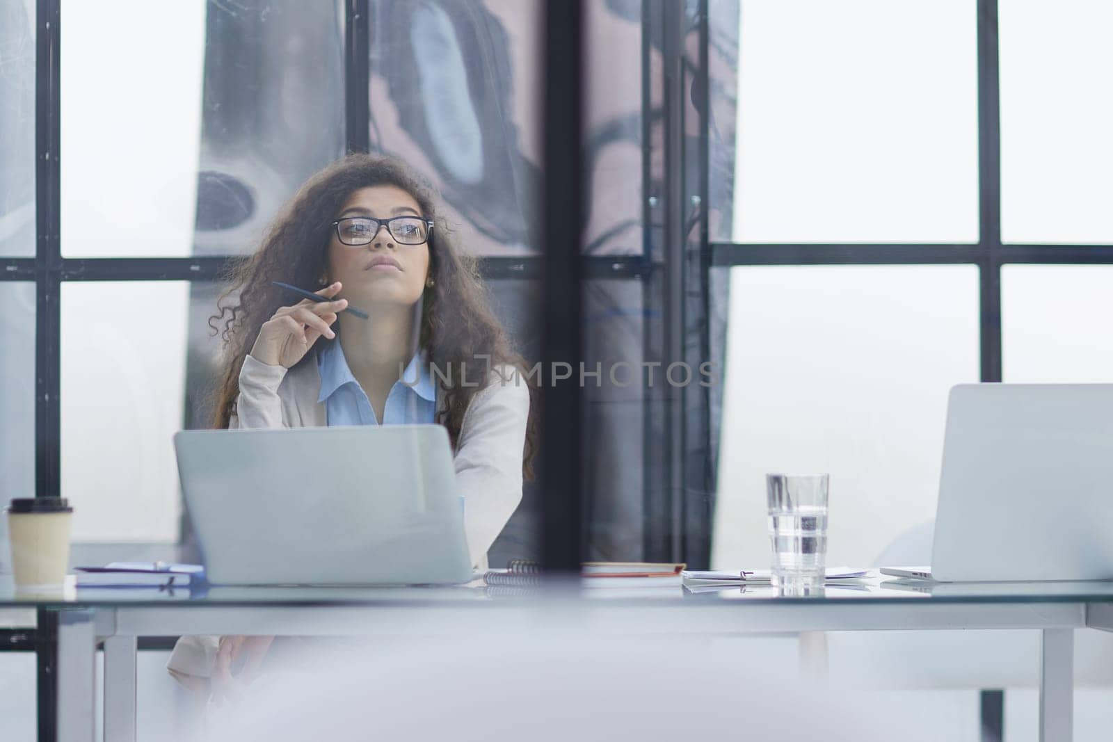 Young businesswoman using laptop at table in office