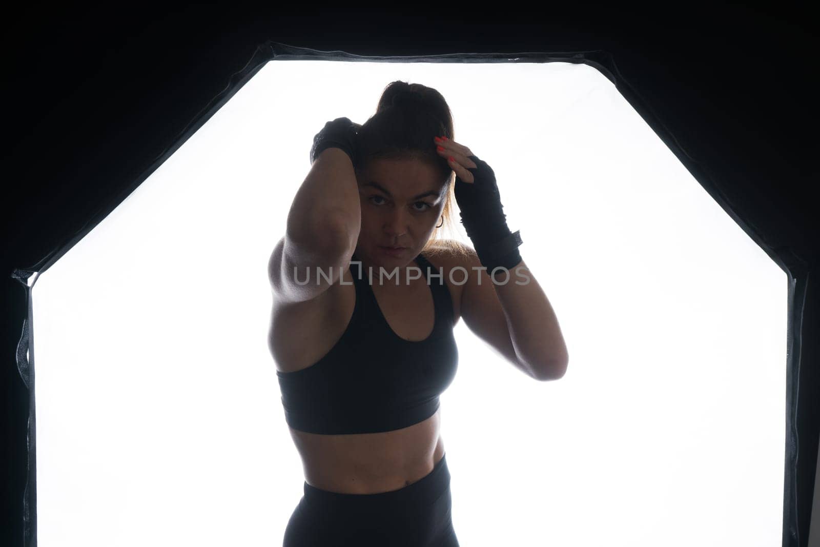 Female boxer training in the dark ring. Slow motion. Silhouette. Boxing concept by Zelenin