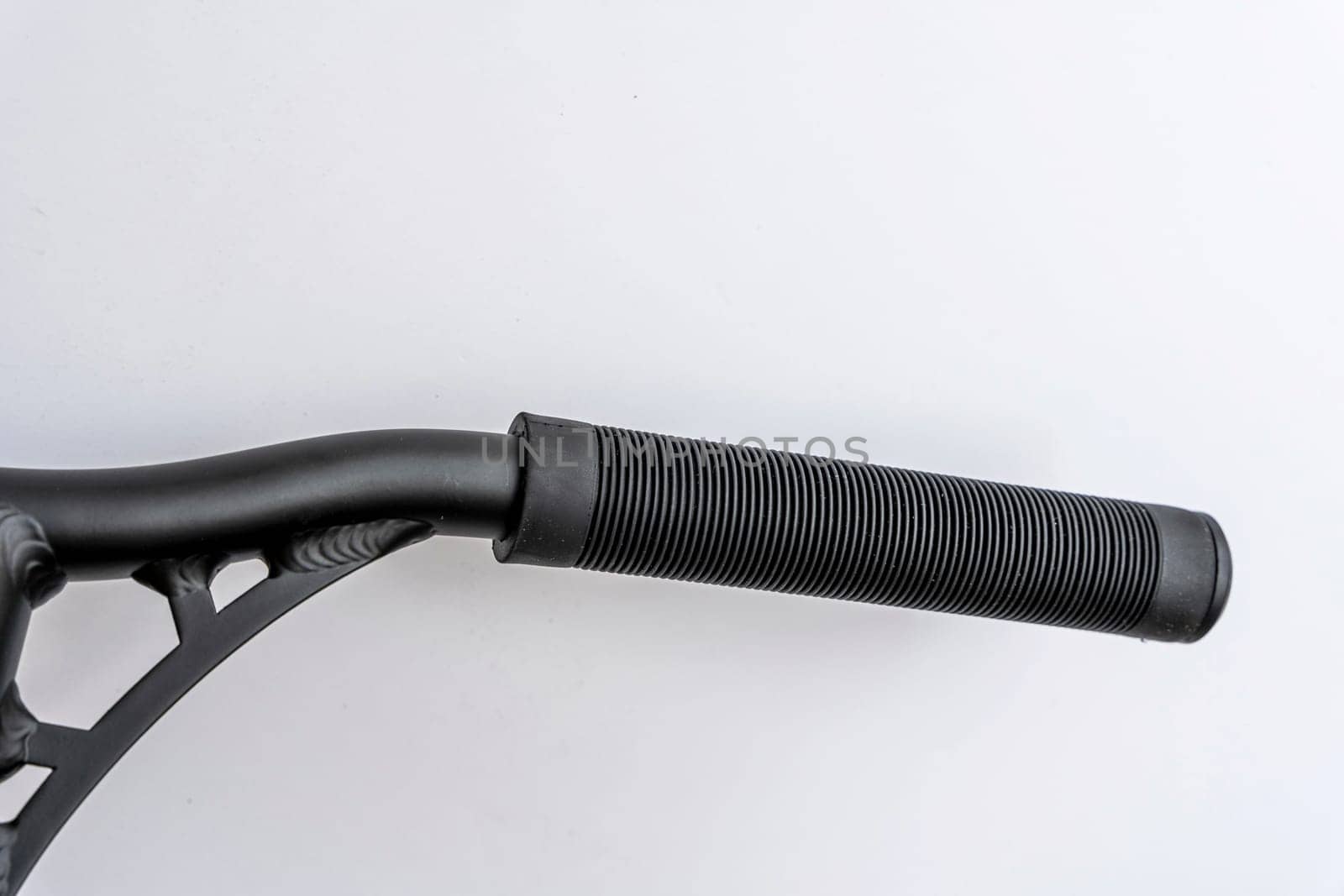 the handle bar of a stunt scooter with black rubber comfortable grips, a stunt scooter, equipment for extreme skating in a skatepark and on a ramp. Details of the scooter. Repair, rental and sale of scooters