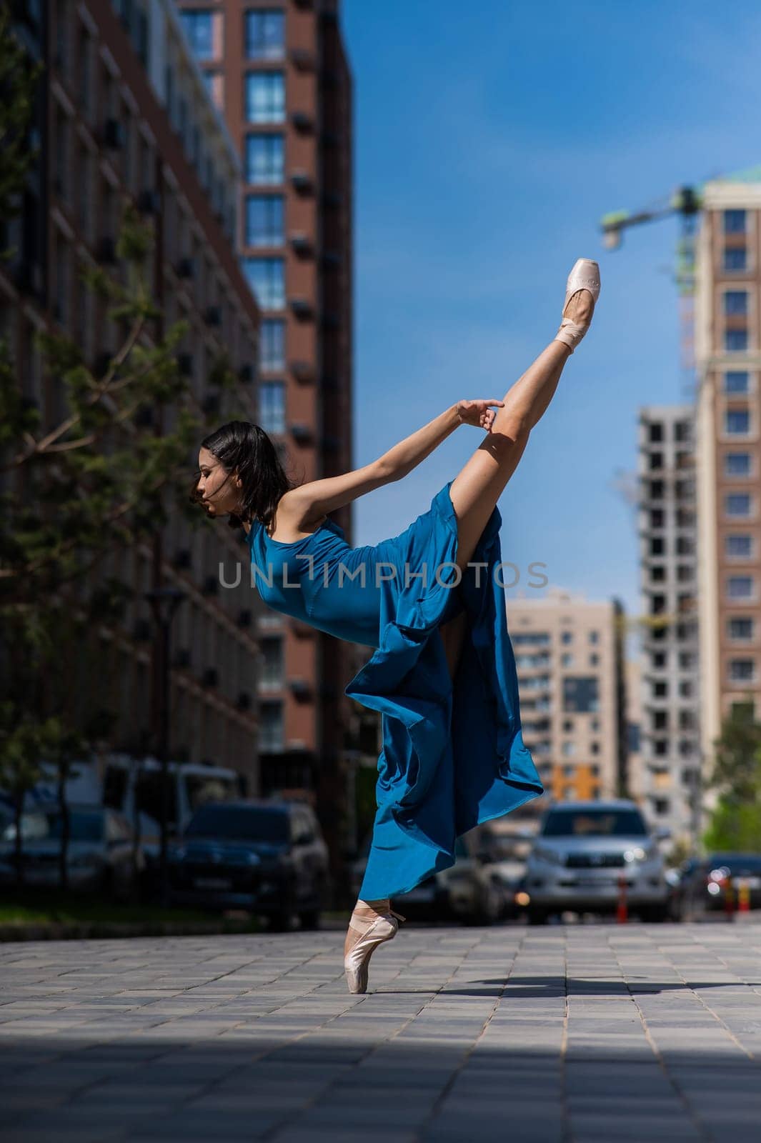 Beautiful Asian ballerina dancing outdoors. Urban landscape