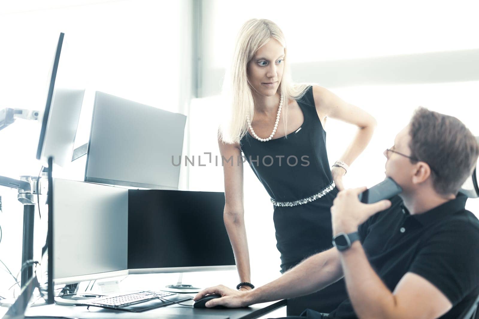 Business people looking at data on multiple computer screens, solving business issue at business meeting in modern corporate office. Business success concept