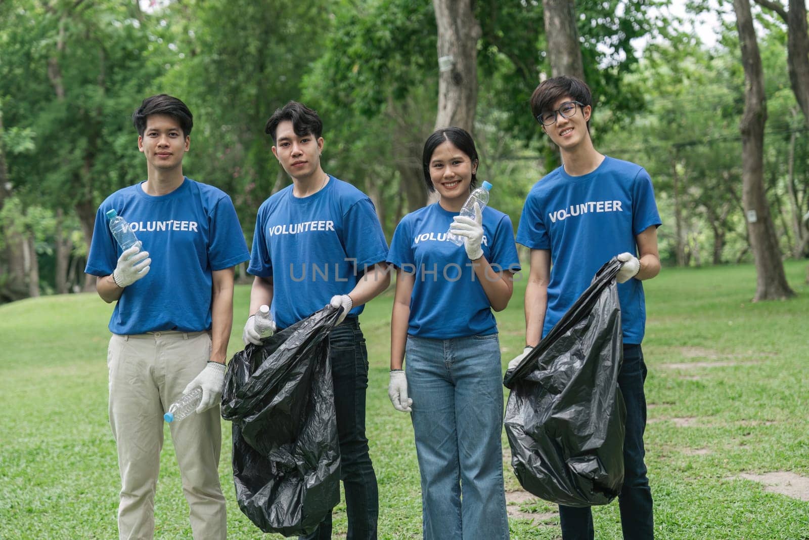 Team volunteers collecting garbage in public park. Environmental protection Concept.