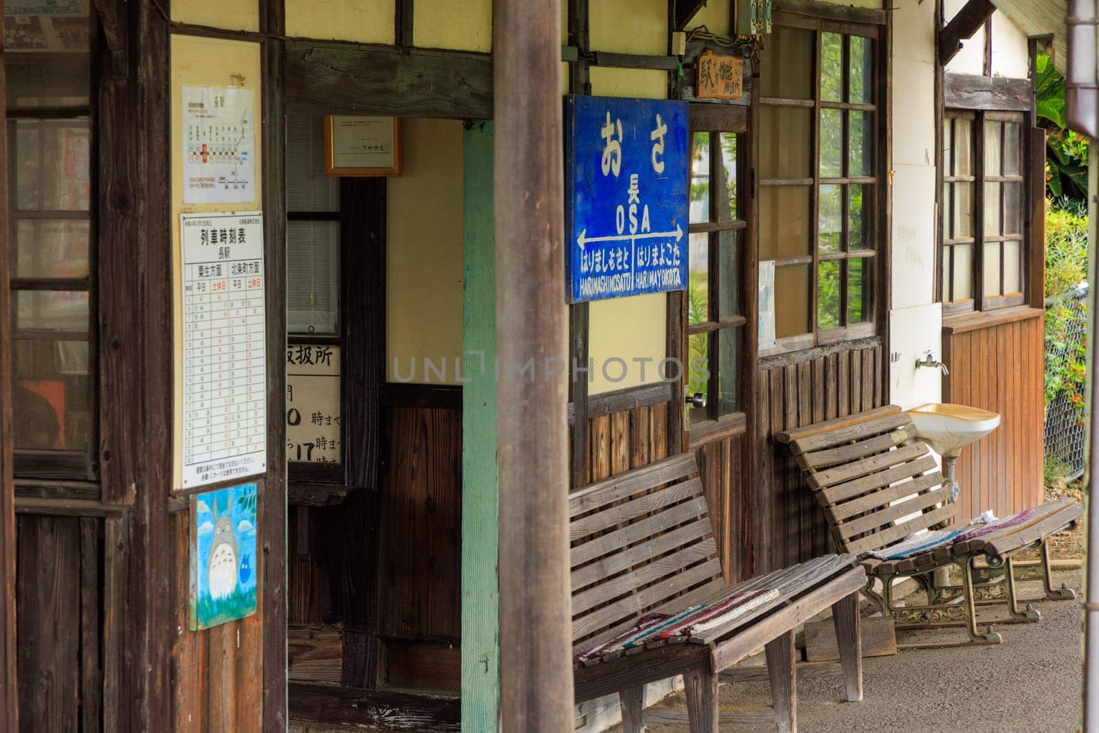 Hyogo, Japan - May 15, 2023: Signs and empty benches at historic unmanned station in rural Japan by Osaze