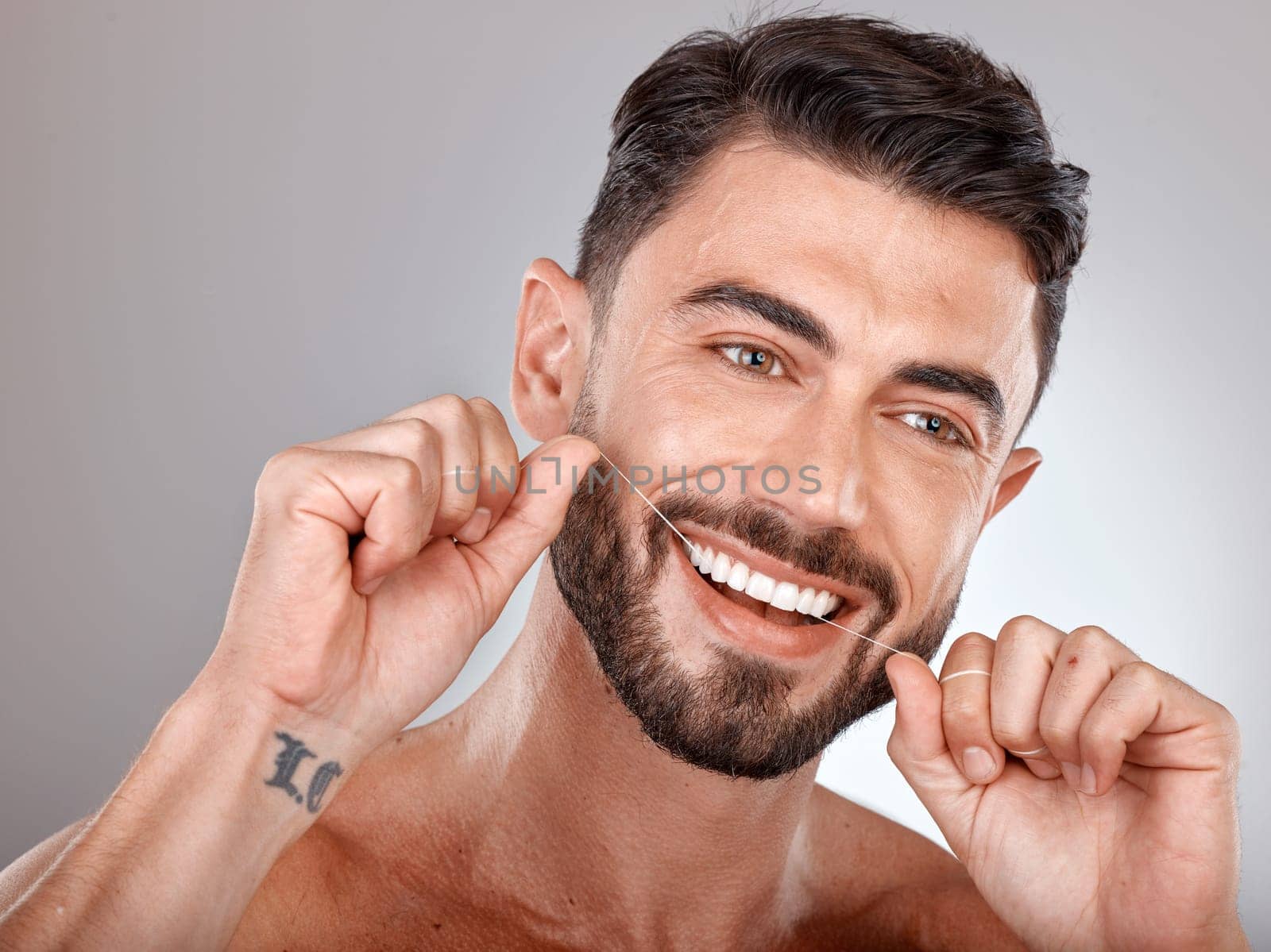 Floss, teeth whitening and happy man with healthy dental lifestyle, wellness or skincare on studio background. Male model face, tooth flossing and cleaning mouth of facial smile, fresh breath or body.