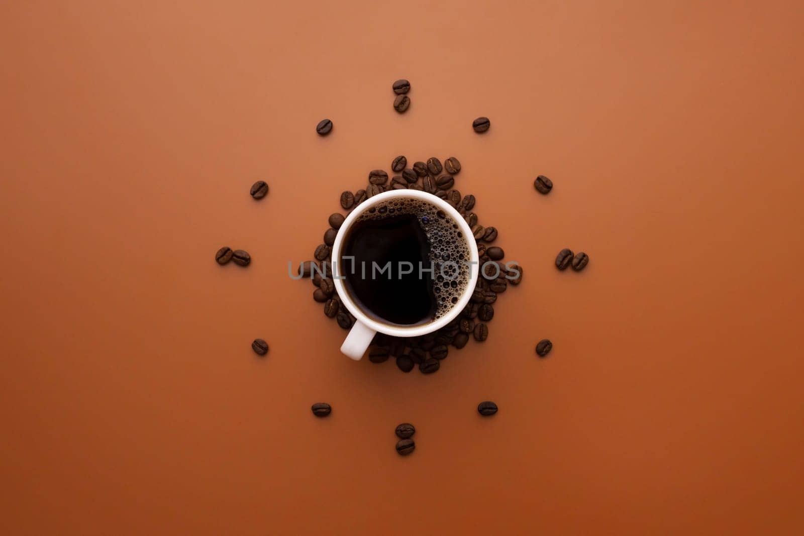 Coffee cup and roasted beans arranged as clock face on brown background. Coffee time concept. Coffee as a symbol of morning energy and vigor or evening refreshment.