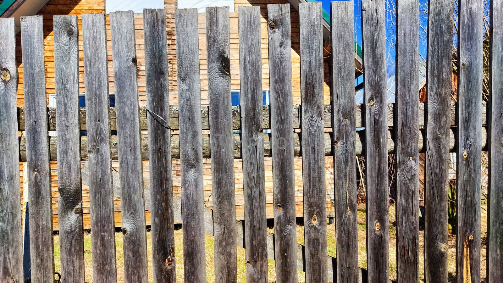 Old wooden planks in fence. Background and texture. Abstract frame and copy space. Ancient Wooden rustic rural fence