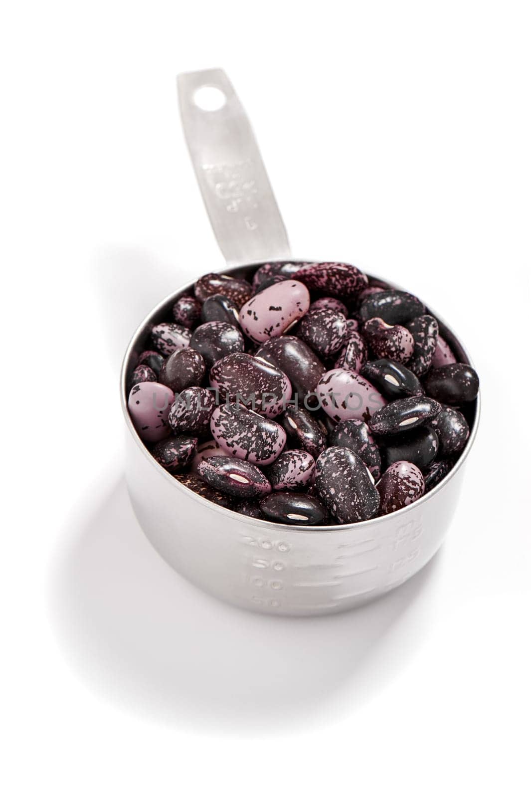 Kidney beans in a measuring cup, white background