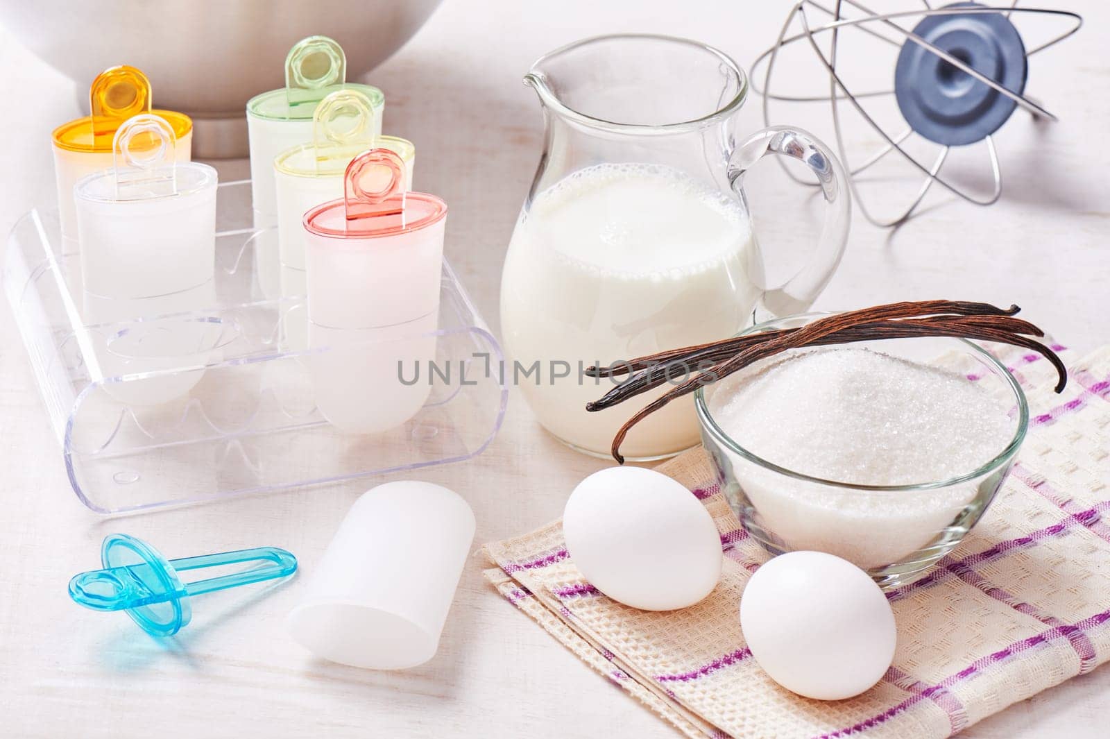 Plastic ice cream lolly form molds stand on plexiglas stand, ingredients for cooking