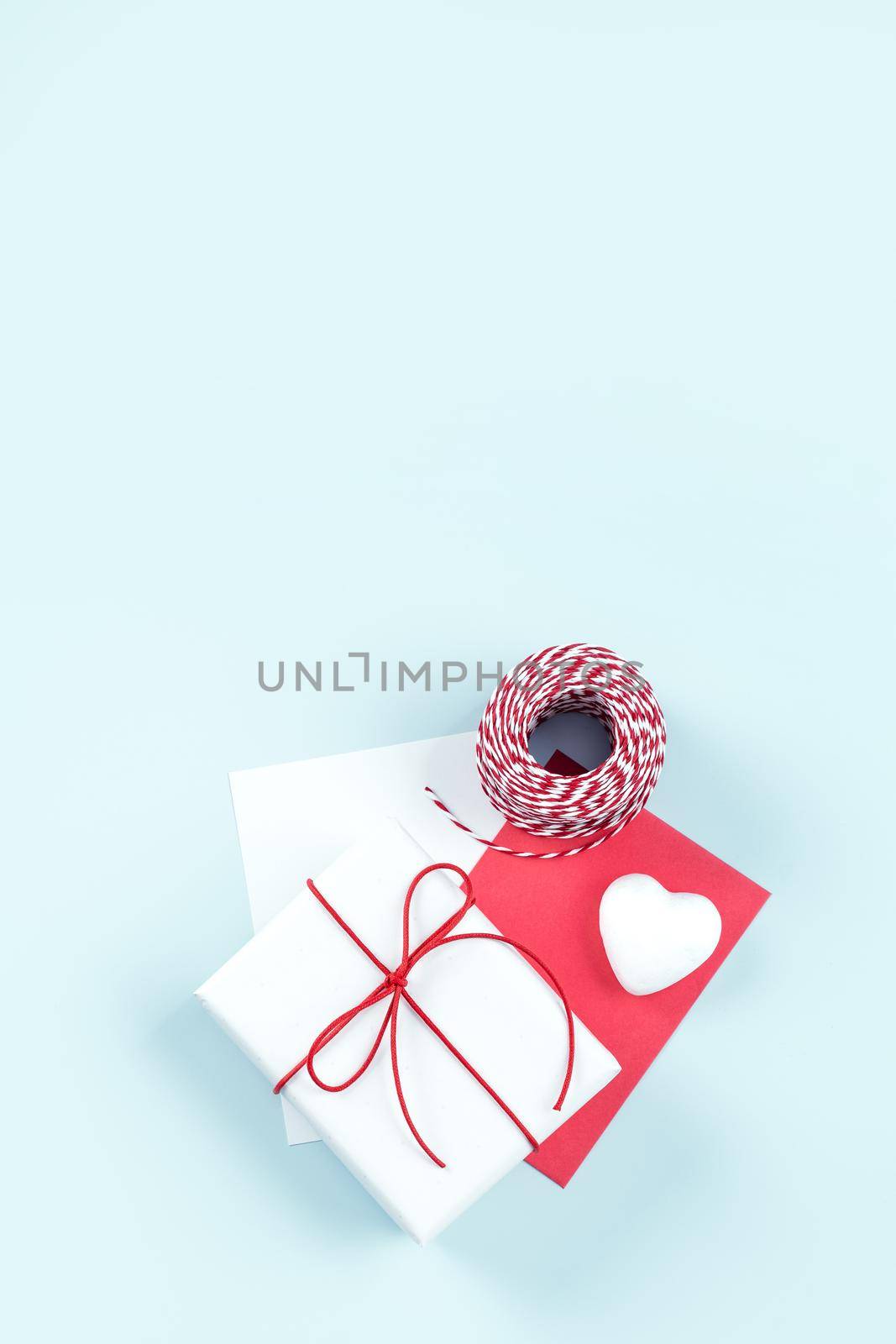 Mother's day, Valentine's Day, handmade gift design concept - Wrapped gift box isolated on pastel light blue color background, flat lay, top view.