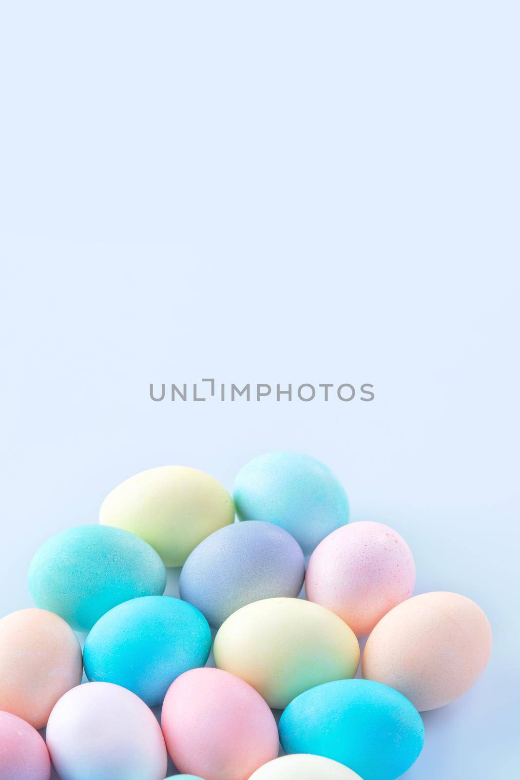 Colorful Easter eggs dyed by colored water isolated on a pale blue background, design concept of Easter holiday activity, close up, copy space. by ROMIXIMAGE