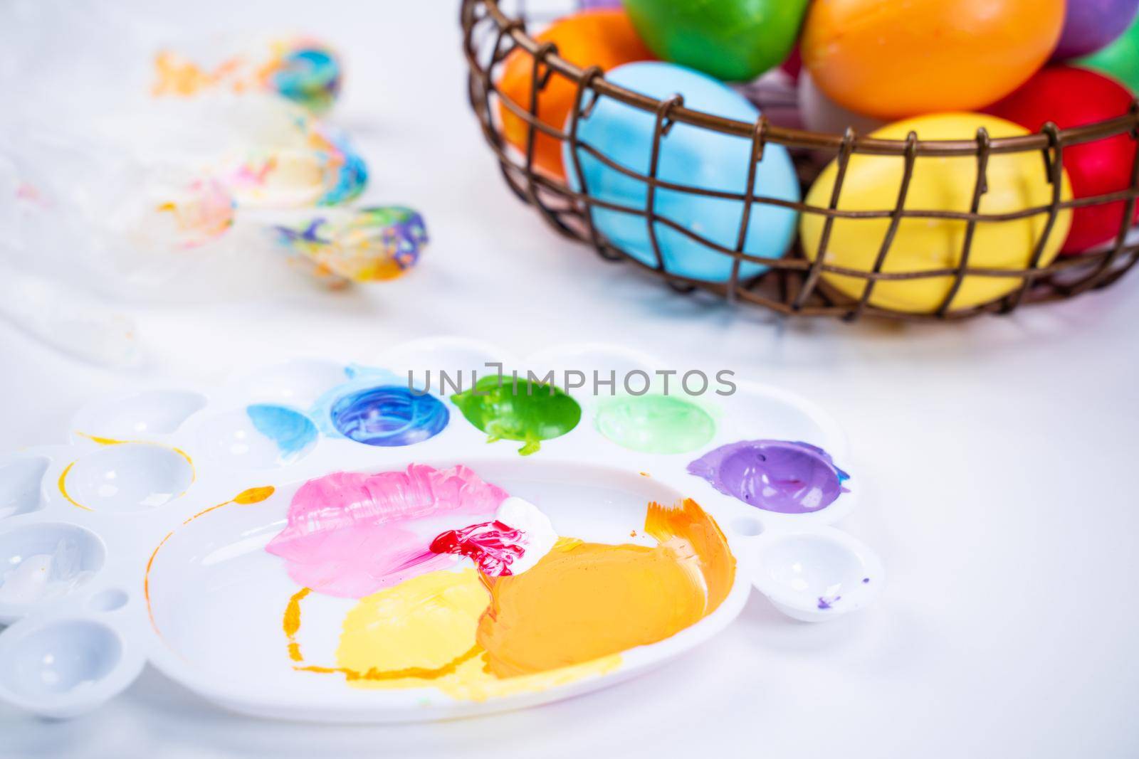 Design concept - Preparing for Easter celebration, painting Easter eggs with colorful Acrylic pigment color dyestuff in palette, close up, lifestyle. by ROMIXIMAGE