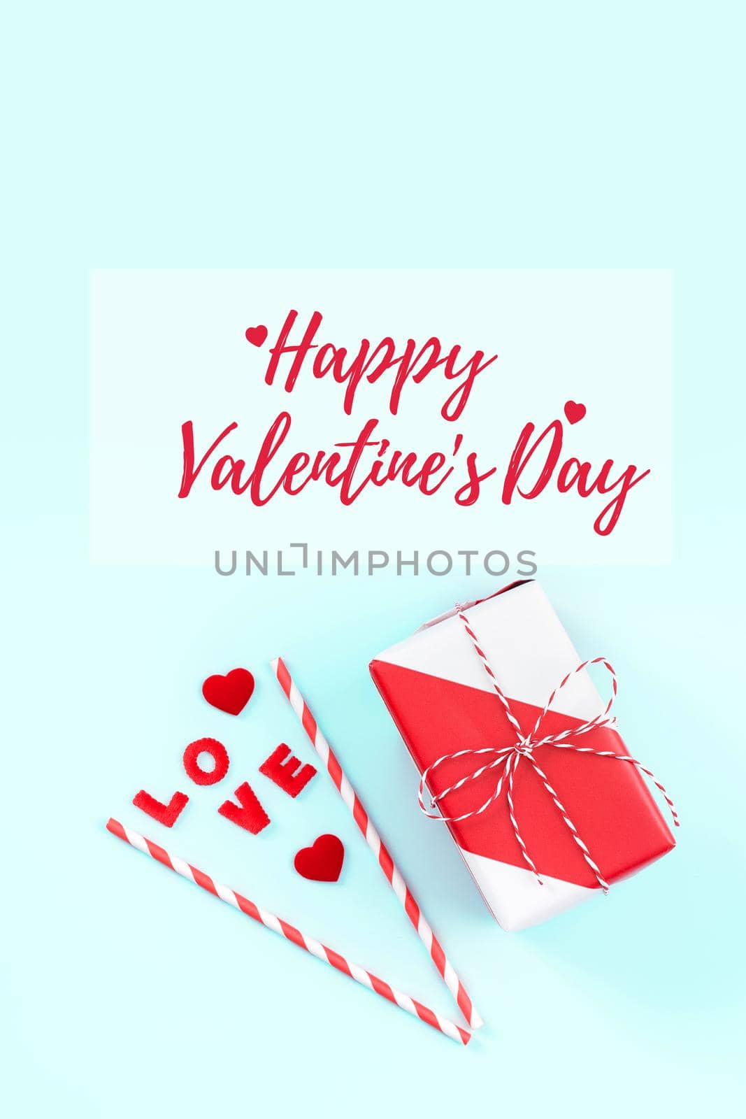 Valentine's Day handmade gift with greeting word design concept - Wrapped gift box isolated on pastel light blue color background, flat lay, top view.
