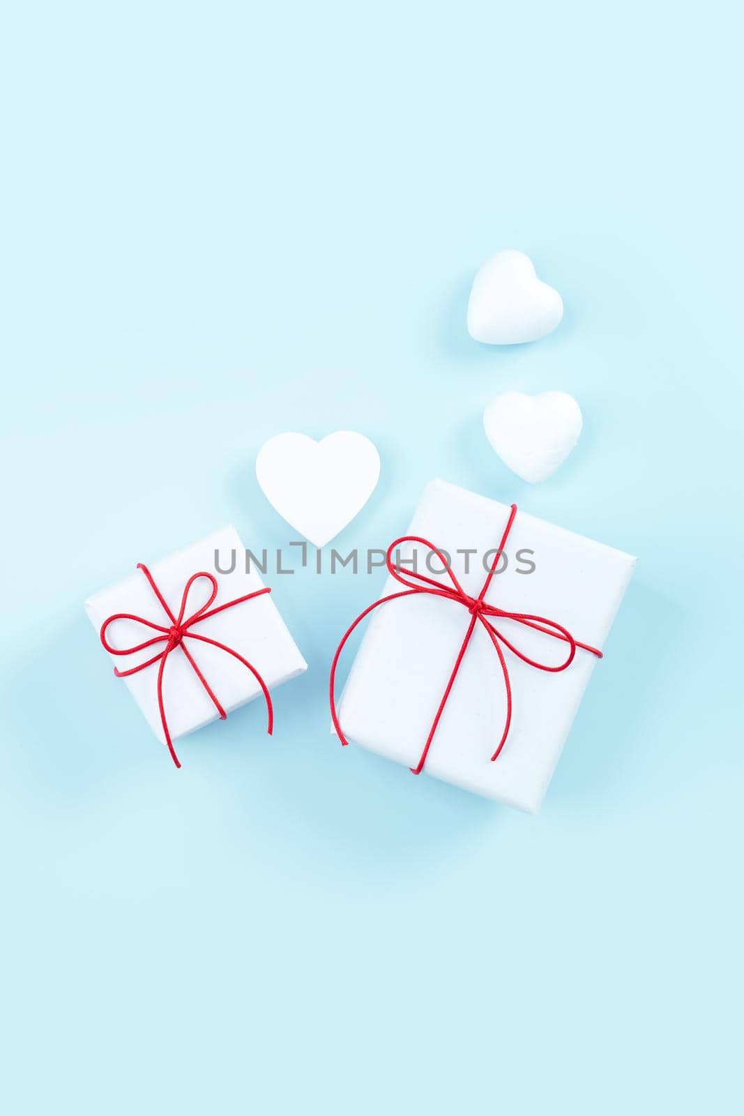 Mother's day, Valentine's Day, handmade gift design concept - Wrapped gift box isolated on pastel light blue color background, flat lay, top view. by ROMIXIMAGE