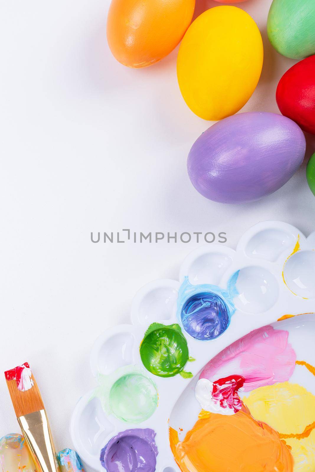 Design concept - Preparing for Easter celebration, painting Easter eggs with colorful Acrylic pigment color dyestuff in palette, top view, lifestyle. by ROMIXIMAGE