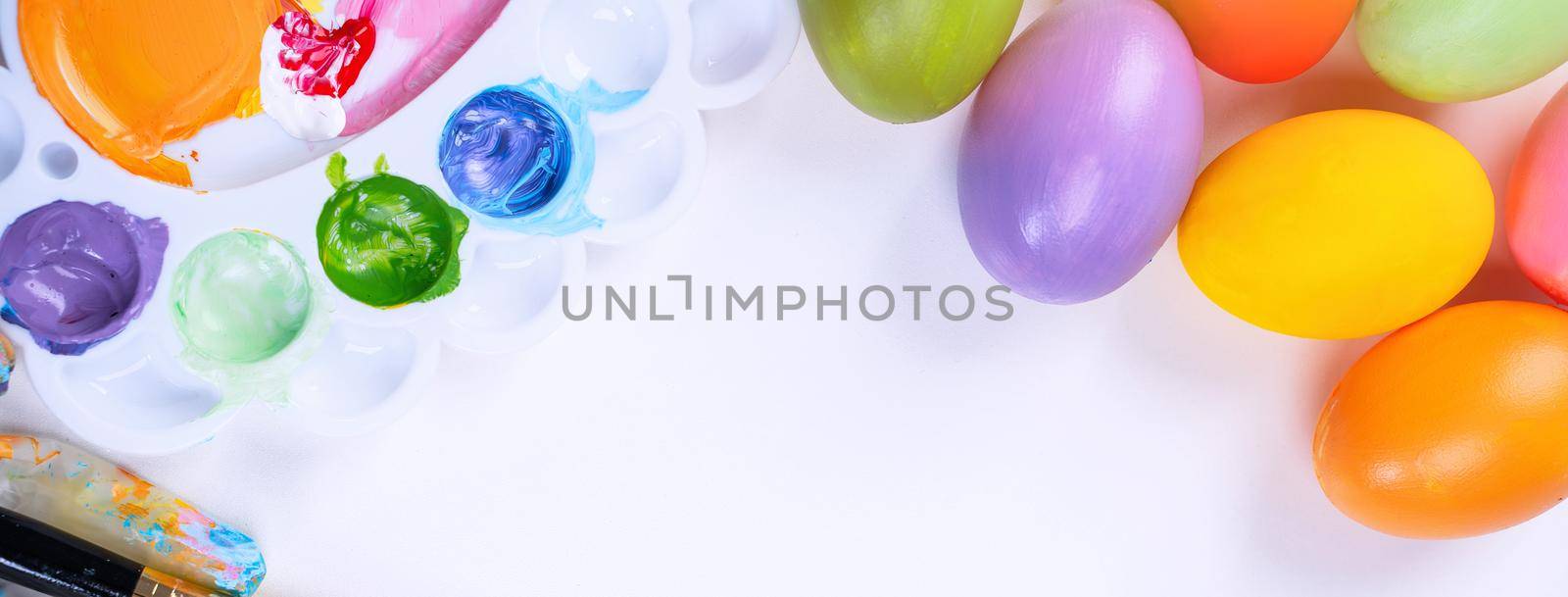 Design concept - Preparing for Easter celebration, painting Easter eggs with colorful Acrylic pigment color dyestuff in palette, top view, lifestyle. by ROMIXIMAGE