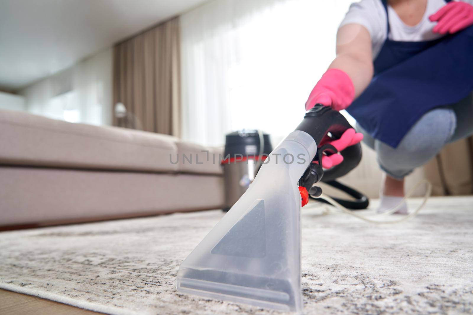Close-up Of A Person Cleaning Carpet With Vacuum Cleaner