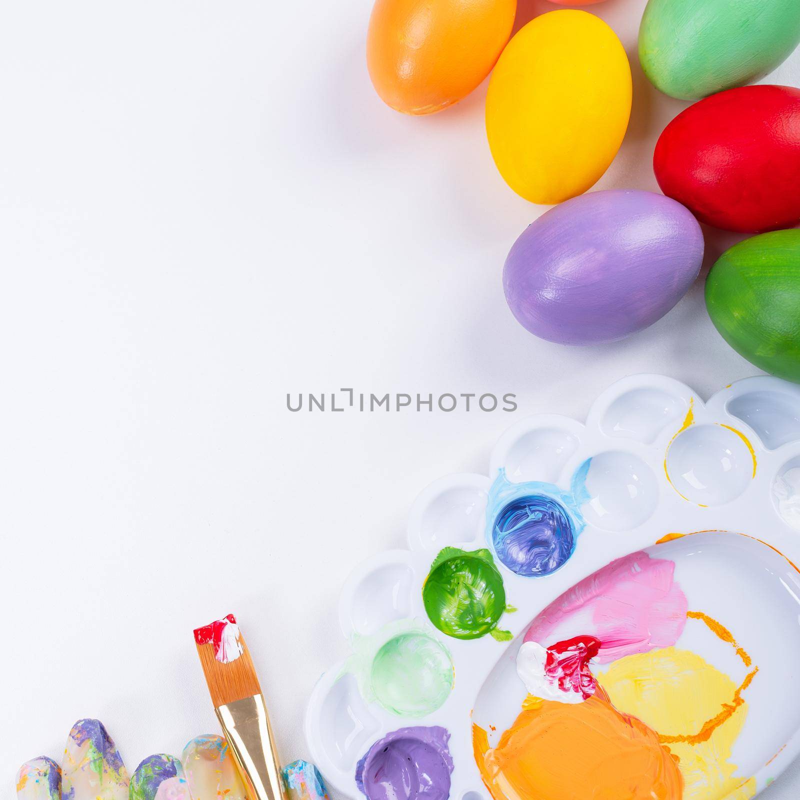 Design concept - Preparing for Easter celebration, painting Easter eggs with colorful Acrylic pigment color dyestuff in palette, top view, lifestyle. by ROMIXIMAGE
