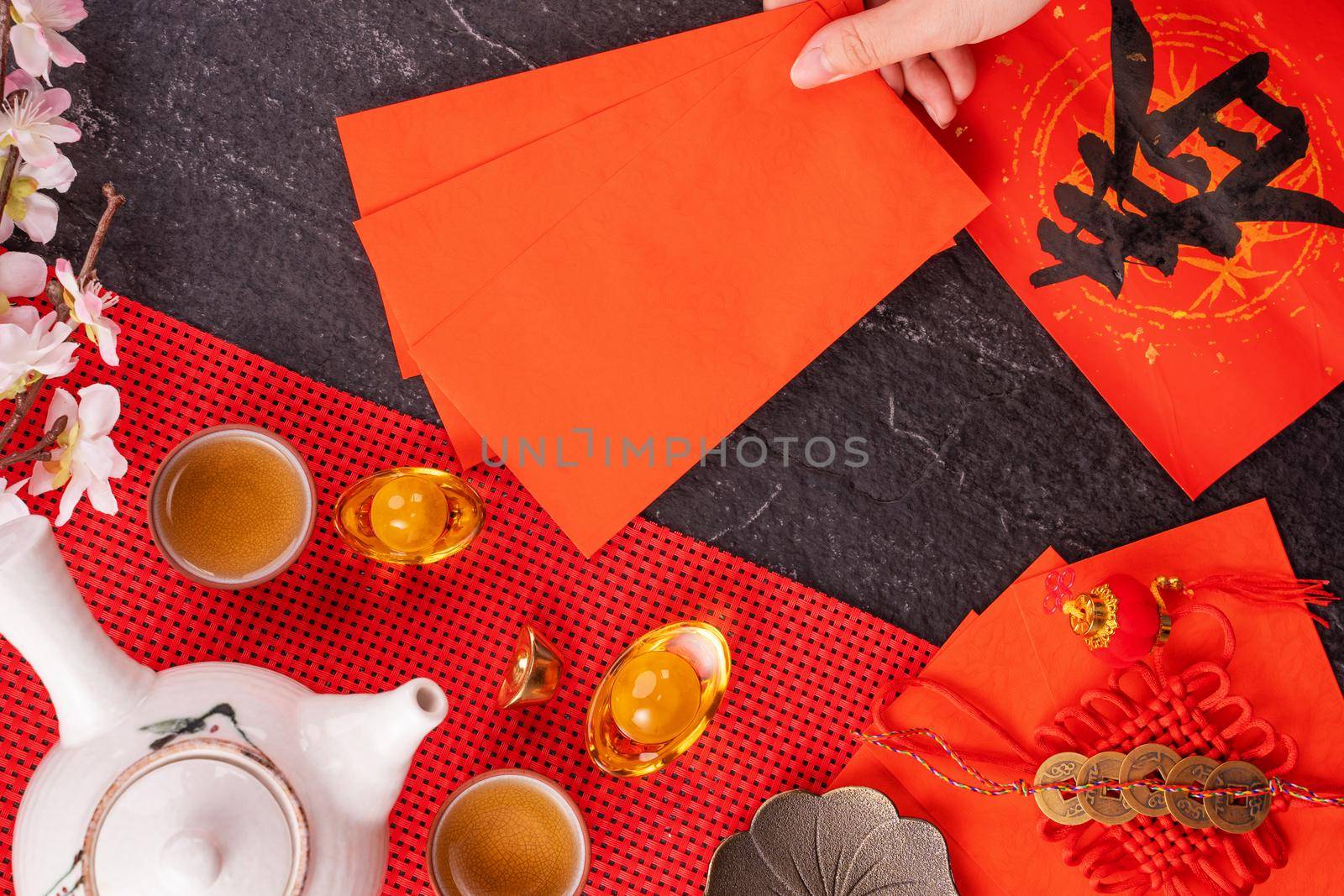 Design concept of Chinese lunar January new year - Woman holding, giving red envelopes (ang pow, hong bao) for lucky money, top view, flat lay, overhead above. The word 'chun' means coming spring. by ROMIXIMAGE
