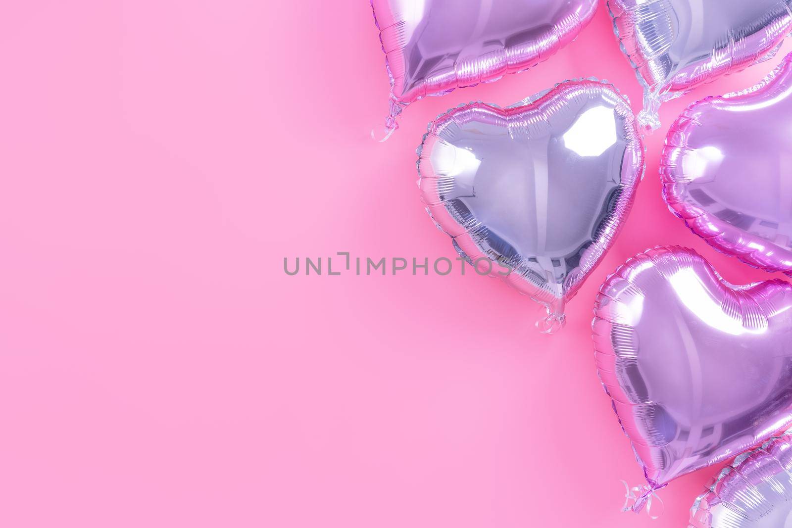 Valentine's Day minimal design concept - Beautiful real heart shape foil balloon isolated on pale pink background, top view, flat lay, overhead above photography.