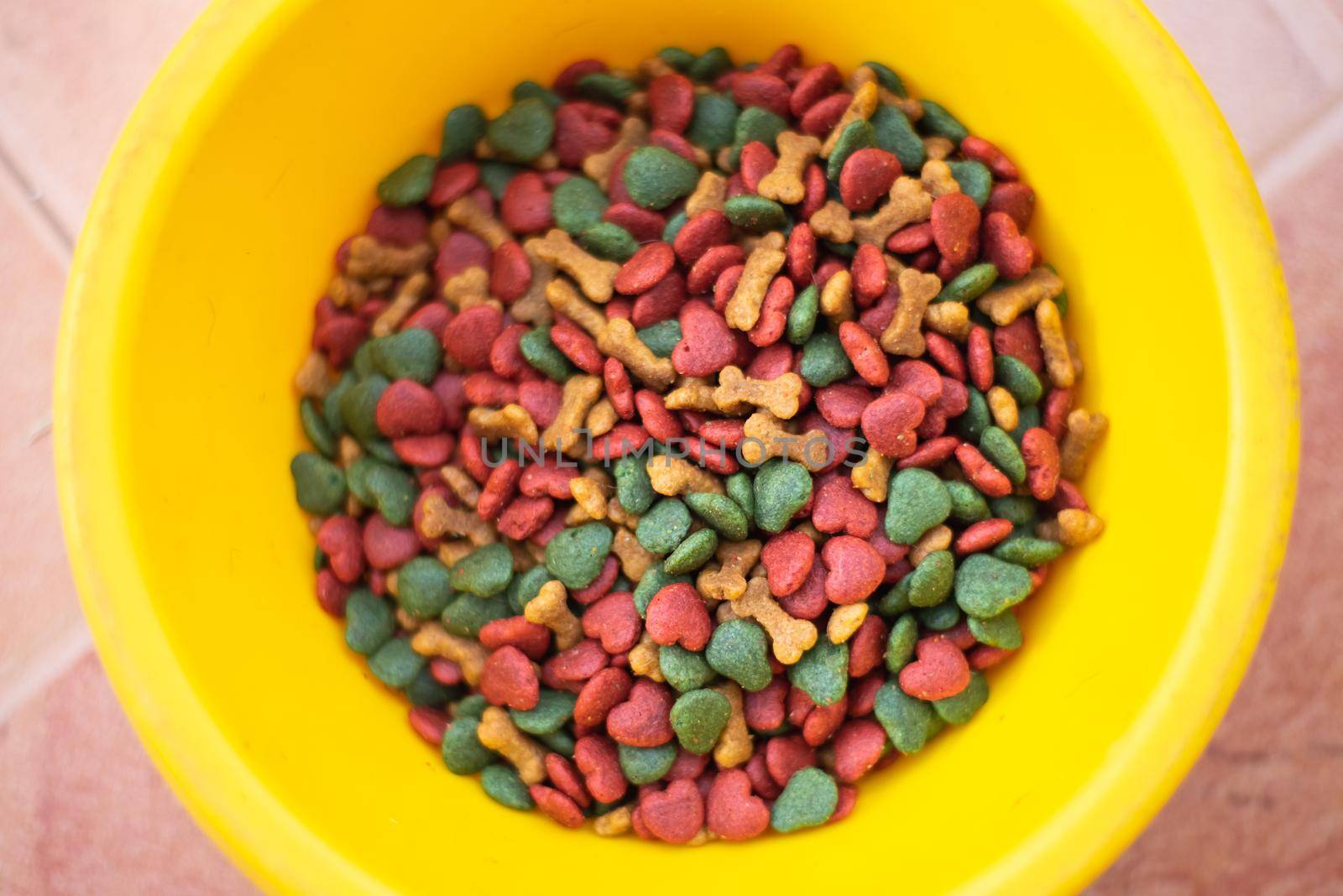 close up of dog food on yellow cup by Wmpix