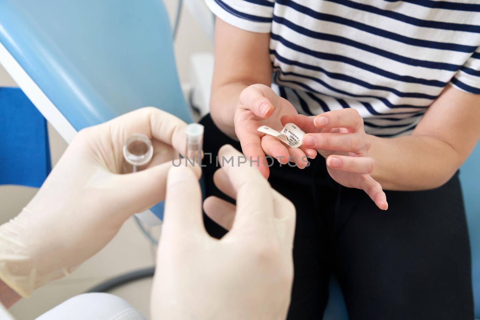 Male dentist showing his female patient a dental implant in modern clinic