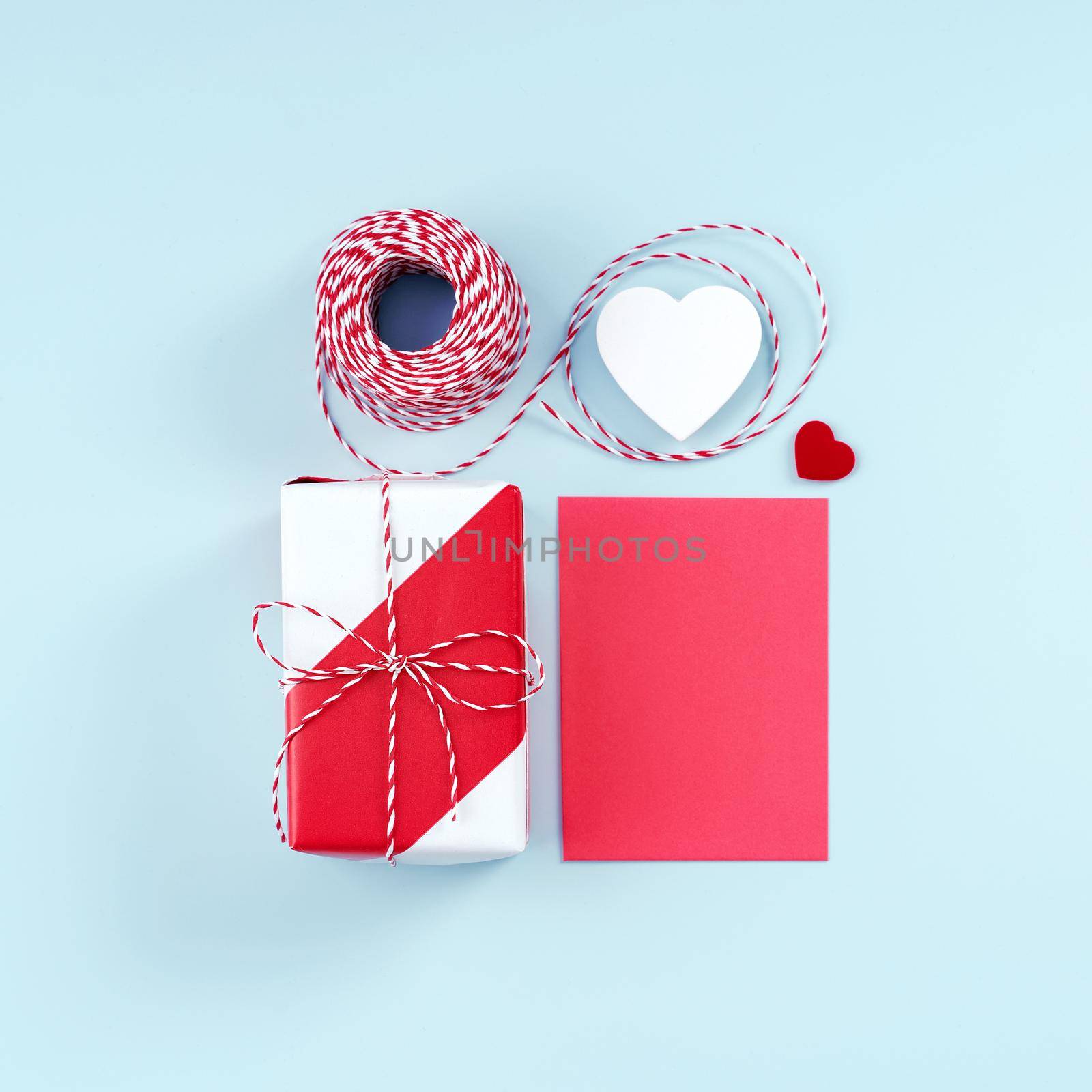 Valentine's Day, Mother's day art design concept for promotion - Red, white wrapped gift box isolated on pastel light blue color background, flat lay, top view. by ROMIXIMAGE