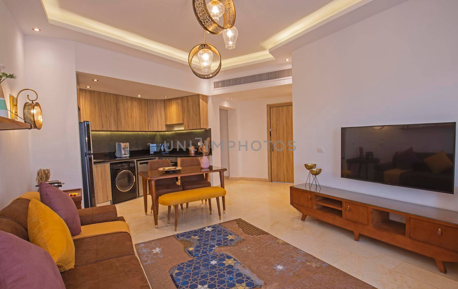Living room lounge area in luxury apartment show home showing interior design decor furnishing with kitchen
