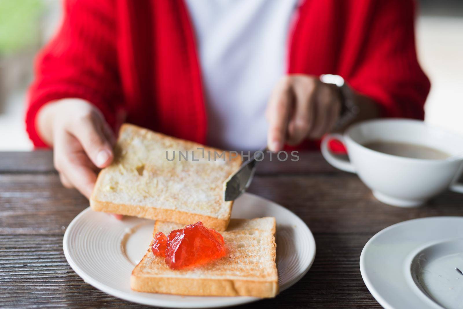 woman having a breakfast on wood table by Wmpix