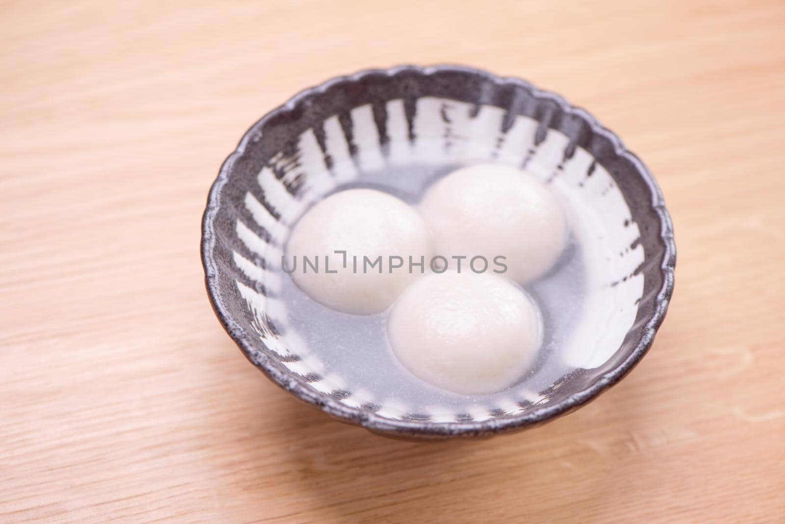 Delicious tang yuan, yuanxiao in a small bowl. Traditional festive food rice dumplings ball with stuffed fillings for Chinese Lantern Festival, close up. by ROMIXIMAGE