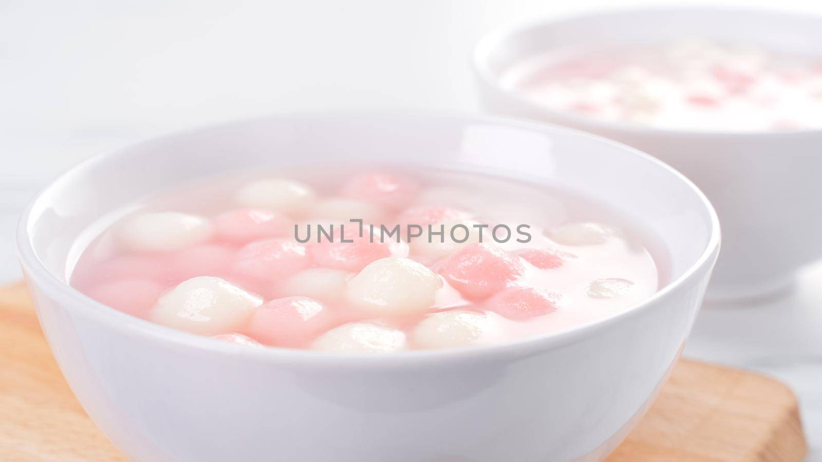 Tang yuan, tangyuan, delicious red and white rice dumpling balls in a small bowl. Asian traditional festive food for Chinese Winter Solstice Festival, close up.