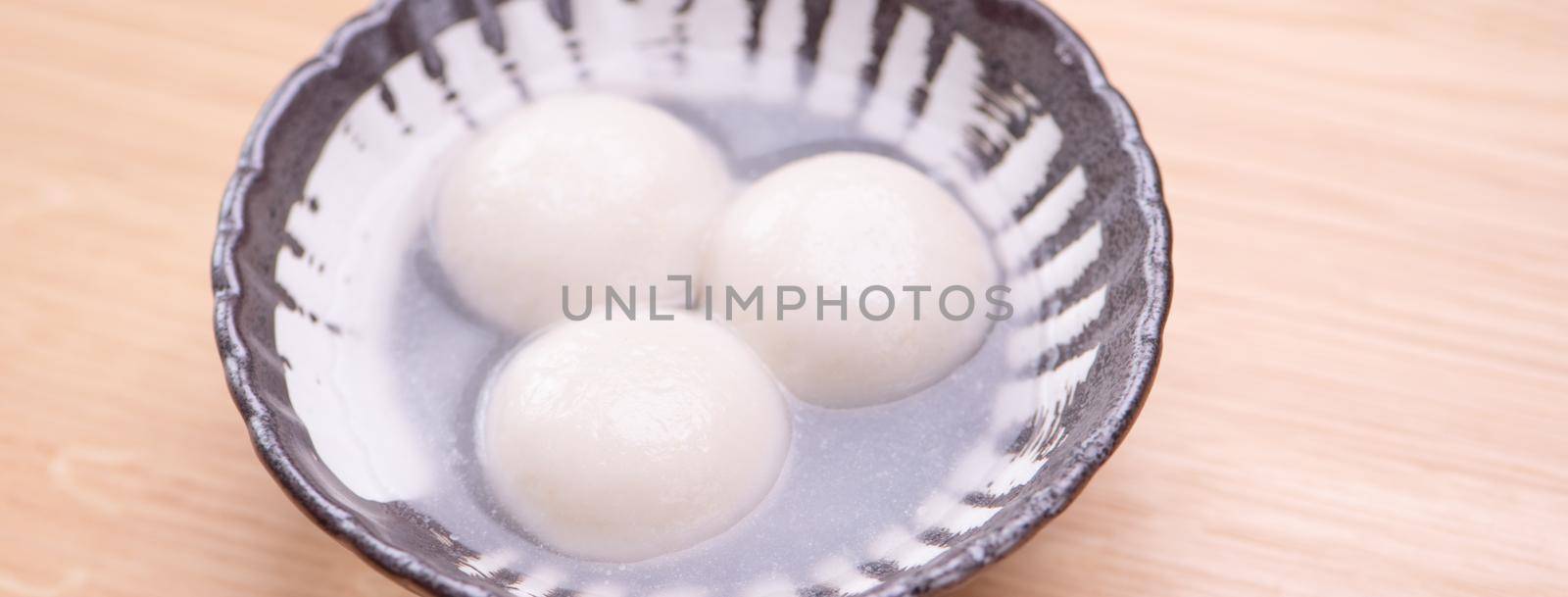 Tang yuan, tangyuan, yuanxiao in a small bowl. Delicious asian traditional festive food rice dumpling balls with stuffed fillings for Chinese Lantern Festival, close up.