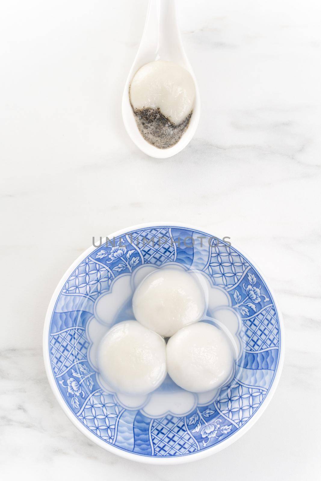 Tang yuan, tangyuan, yuanxiao in a small bowl stuffed with sesame fillings, top view, flat lay. Delicious asian food rice dumpling balls for festival.