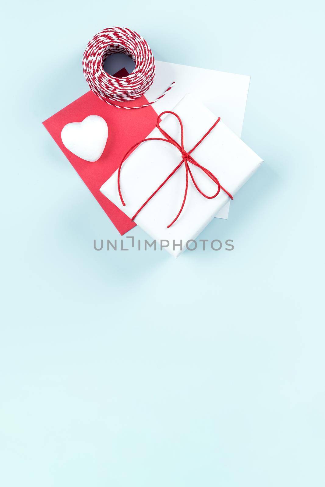Mother's day, Valentine's Day handmade gift design concept - Wrapped gift box isolated on pastel light blue color background, flat lay, top view. by ROMIXIMAGE