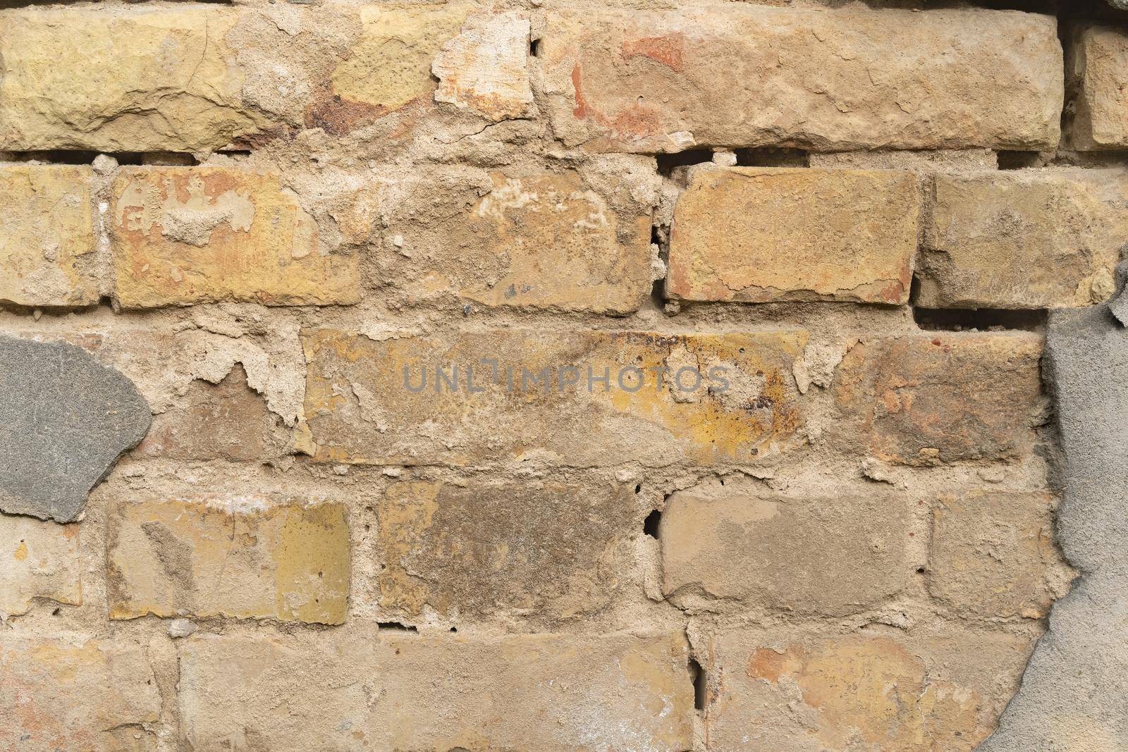 Texture of outer brick wall with old fallen cladding. Old building with falling off plaster. Background of brick wall pattern.